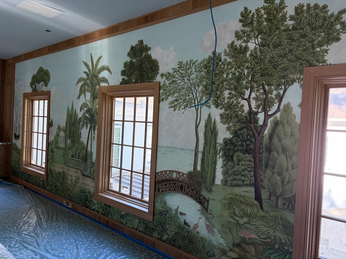 Panoramic tree and landscape mural installed around three windows
